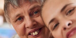 Zwei Frauen machen ein Selfie, lächeln dabei.