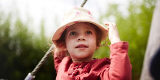 Ein junges Mädchen spielt zufrieden auf dem Spielplatz.
