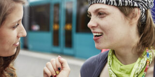 Junge Frauen sind gemeinsam unterwegs, warten auf einem Bahnsteig.