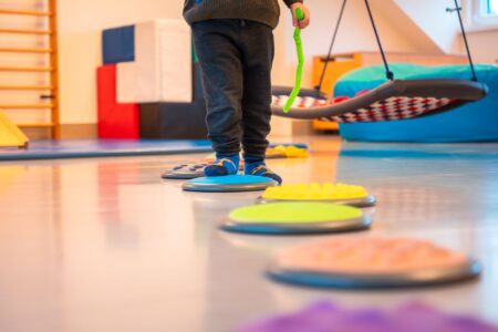 Kinderfüße und ein Parcours auf Turnhallenboden.