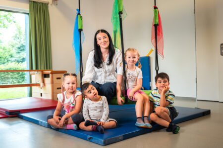 Azubi Sophia van Leuwen in der Kita Wiesenzauber mit vier Kindern in der Turnhalle.