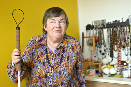 Blinde Frau blickt zufrieden in die Kamera.